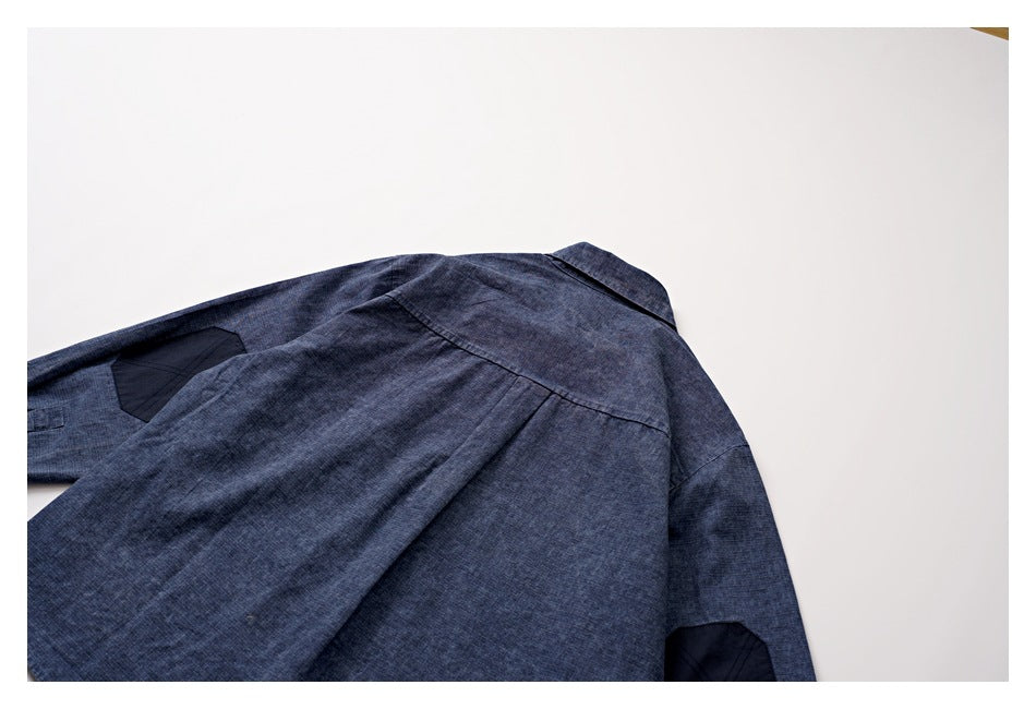 Close-up of the back shoulder and seams of a dark blue garment laid flat.