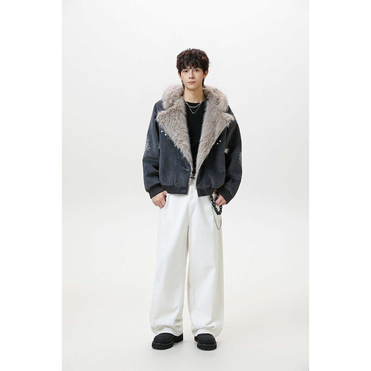 Full-length view of a model wearing a charcoal faux-fur-collar jacket with wide white trousers.