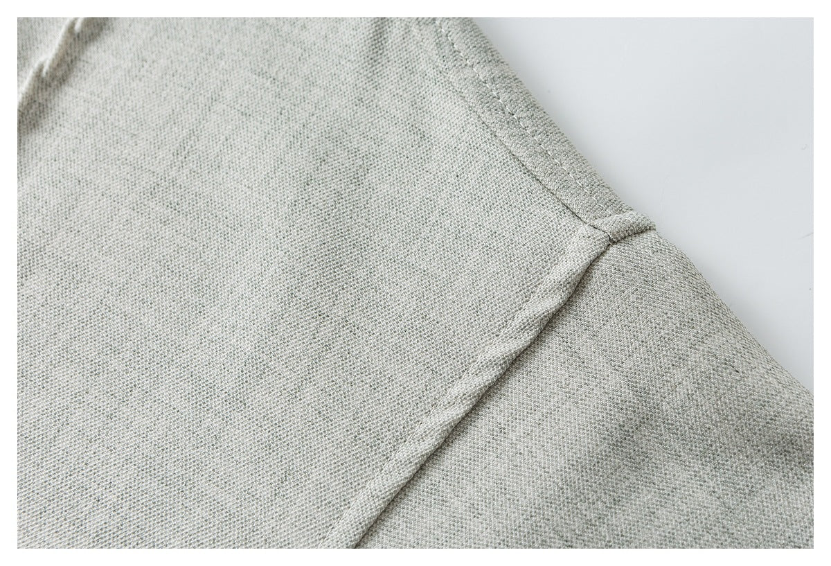 Close-up of the light gray shirt shoulder seam and sleeve attachment.