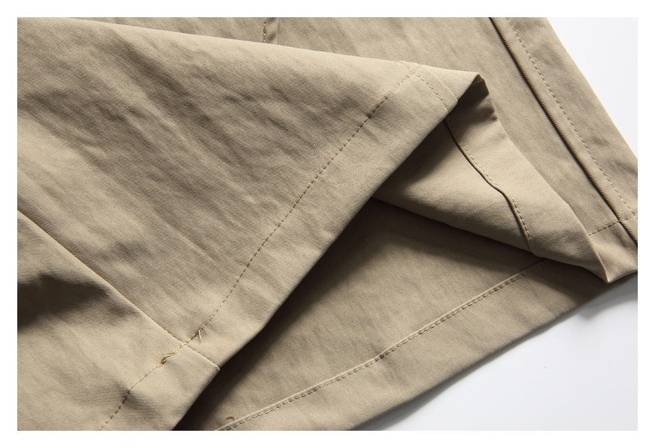 Close-up of the stitched hem and folded edge of khaki shorts.