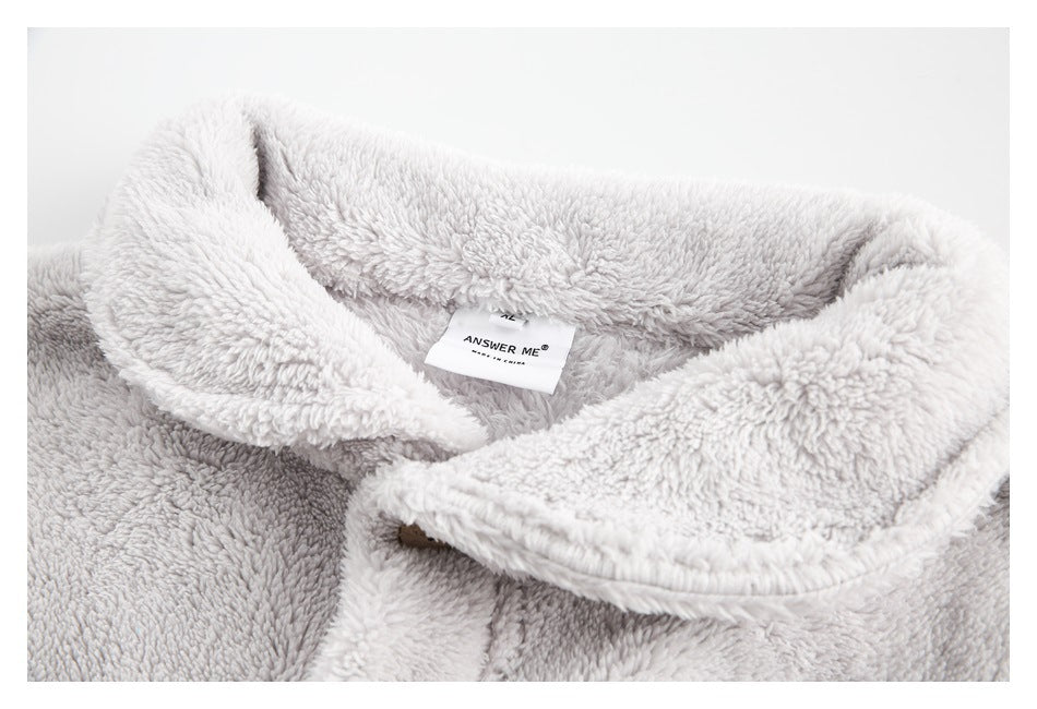 Close-up of a pale gray plush garment's wide collar and sewn-in ANSWER ME neck label.