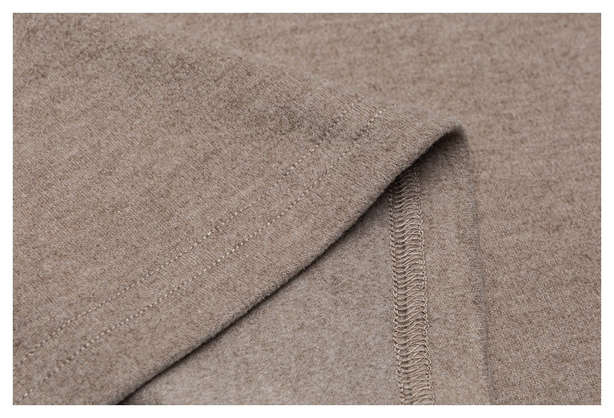 Close-up of a taupe garment hem with parallel topstitching and an overlocked seam.