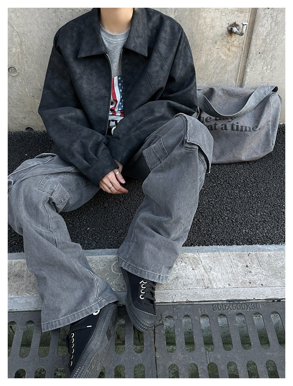 Seated model in a dark charcoal zip-front jacket and loose gray cargo pants, with a gray tote nearby.