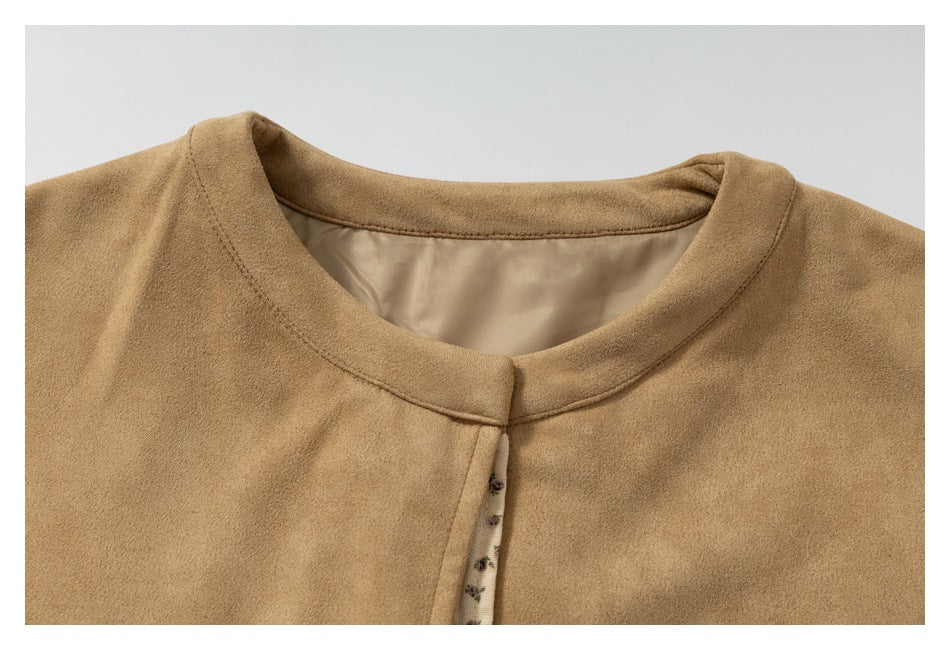 Close-up of the tan jacket's rounded neckline, smooth inner lining, and floral-trimmed front edge.