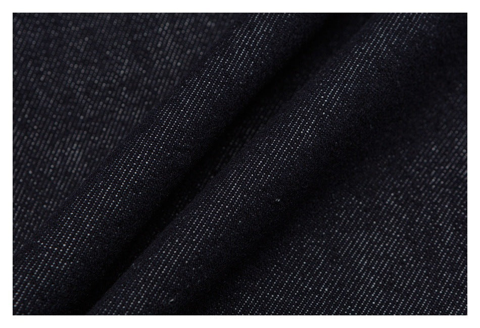 Macro view of dark indigo denim fabric with a fine diagonal weave.