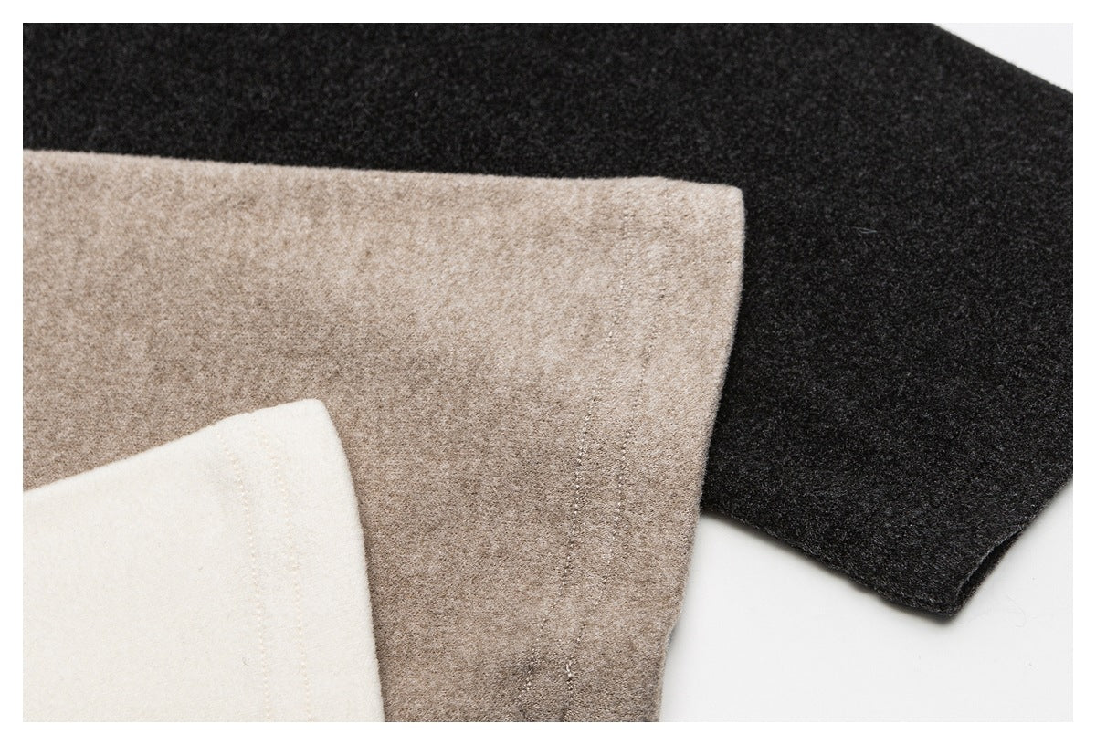 Close-up of overlapping black, taupe, and ivory garment fabric panels.