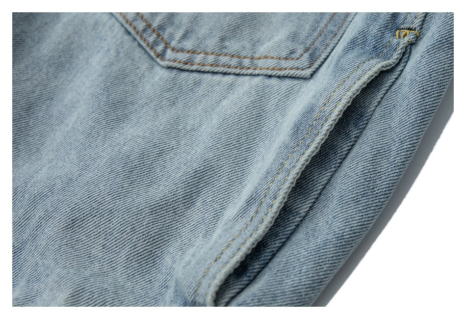Close-up of light-wash denim fabric, pocket stitching, and a folded seam.