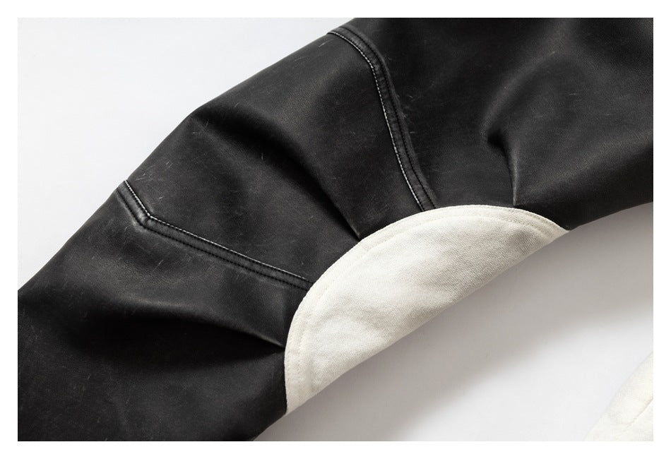 Close-up of a black jacket sleeve with stitched panel seams and an off-white inset panel.