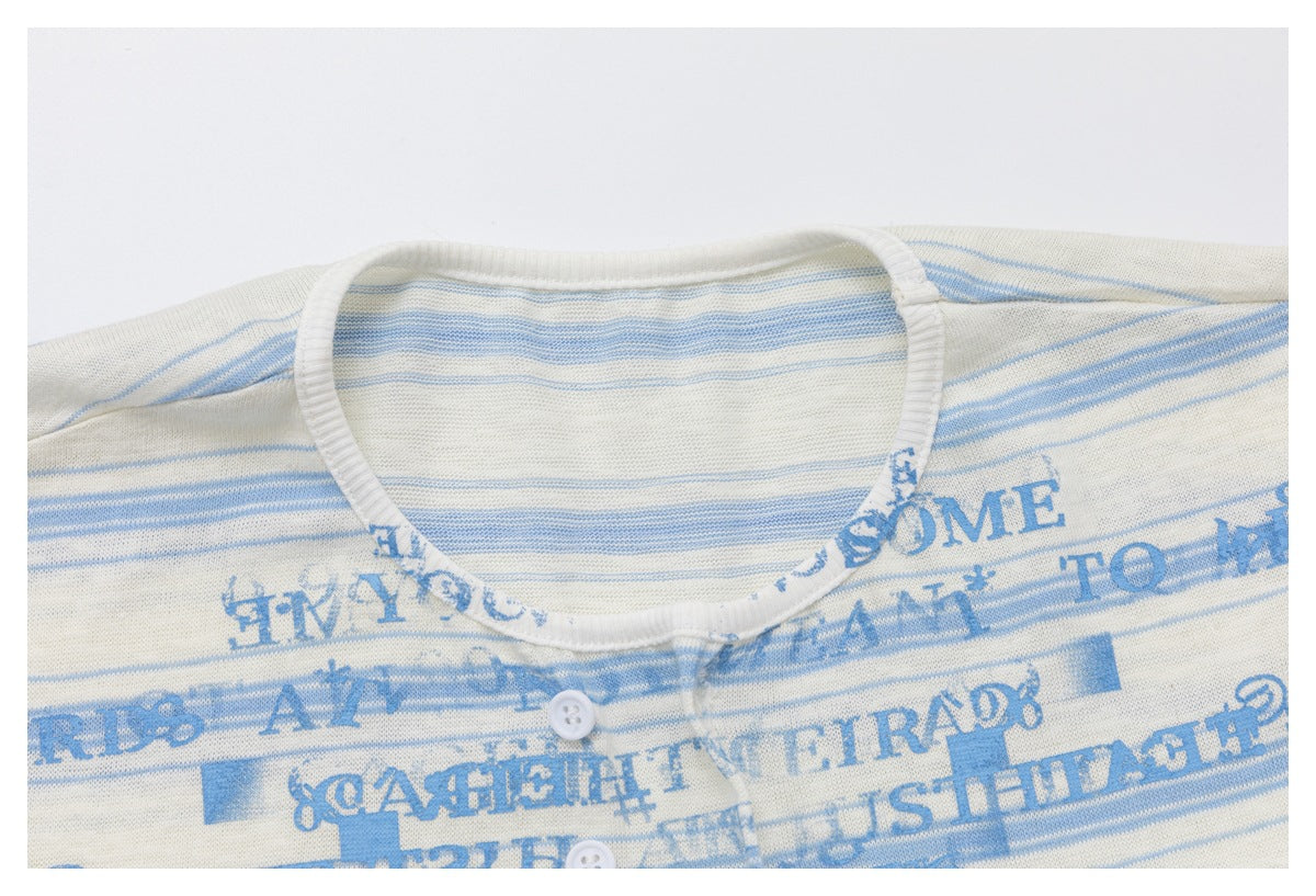 Close-up of the top's ribbed neckline, striped fabric, blue text print, and button placket.