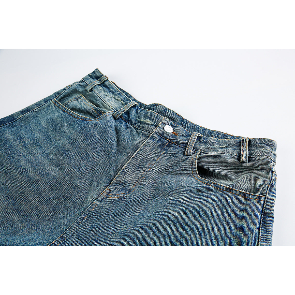 Close-up of the front waist and pockets of faded blue denim shorts, with a metal button and belt loops.