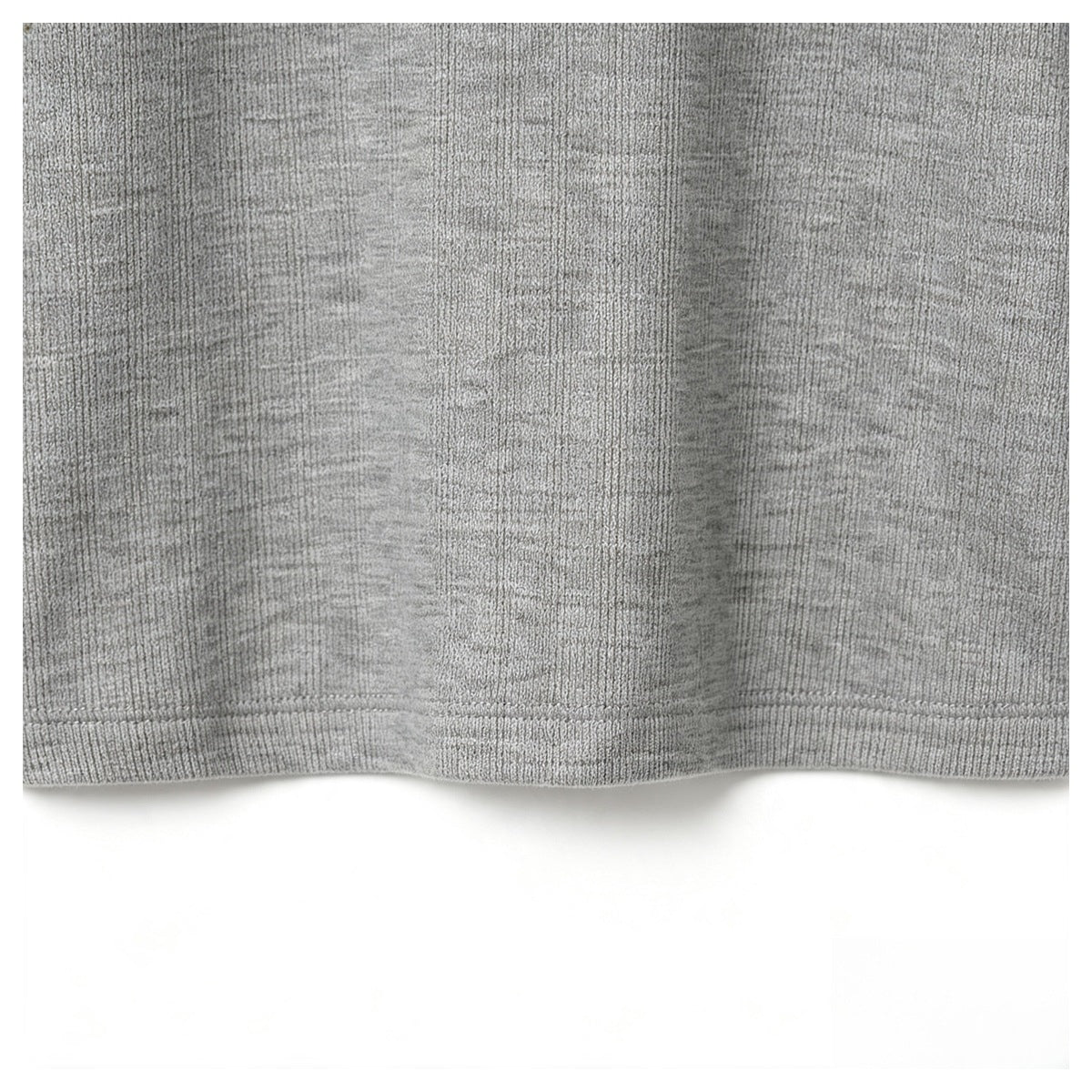 Close-up of the gray garment's straight stitched hem and ribbed knit texture.