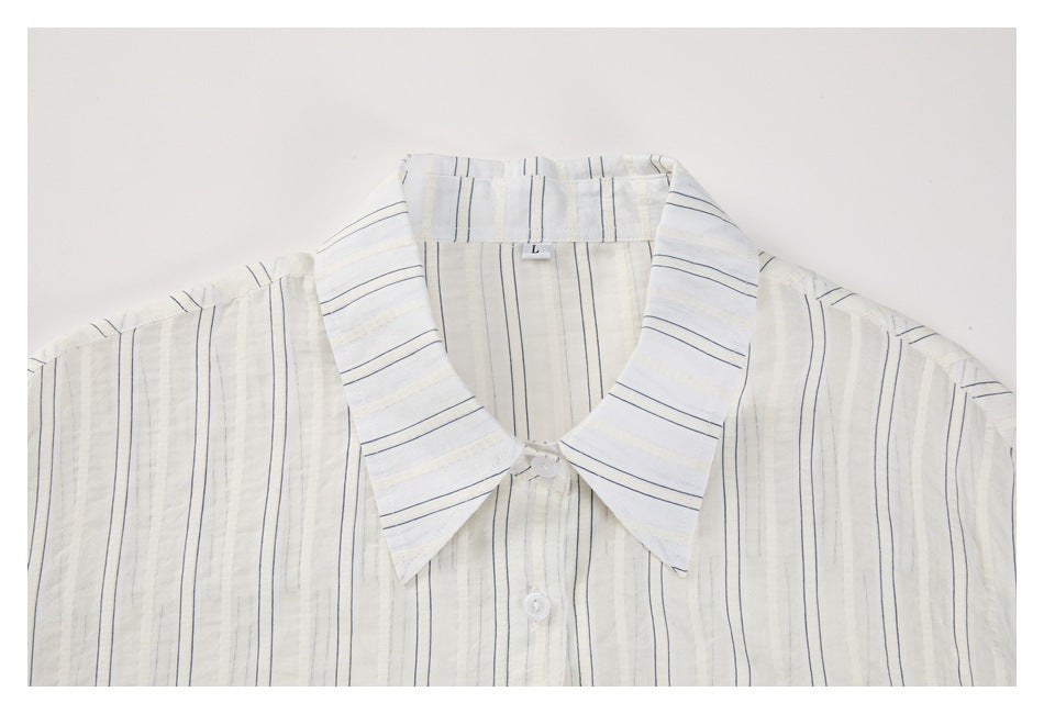 Upper front of an ivory button-up shirt with thin navy stripes and a wide pointed collar.