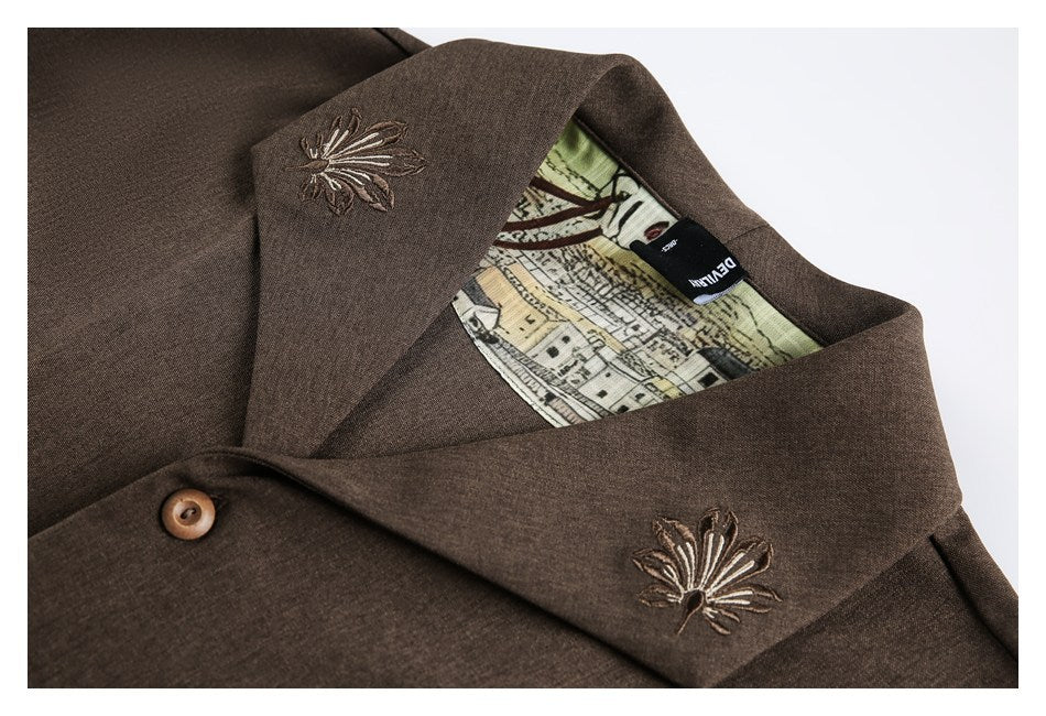 Close-up of a brown garment collar with floral embroidery, a button, and illustrated lining.