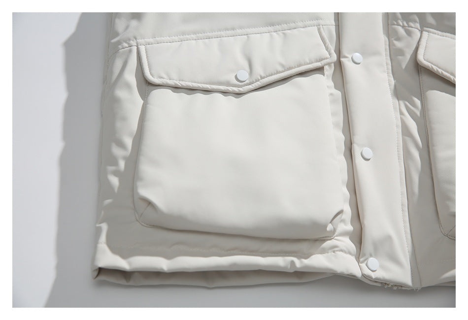 Close-up of an ivory jacket’s flap pocket, white snap, and center snap-button placket.