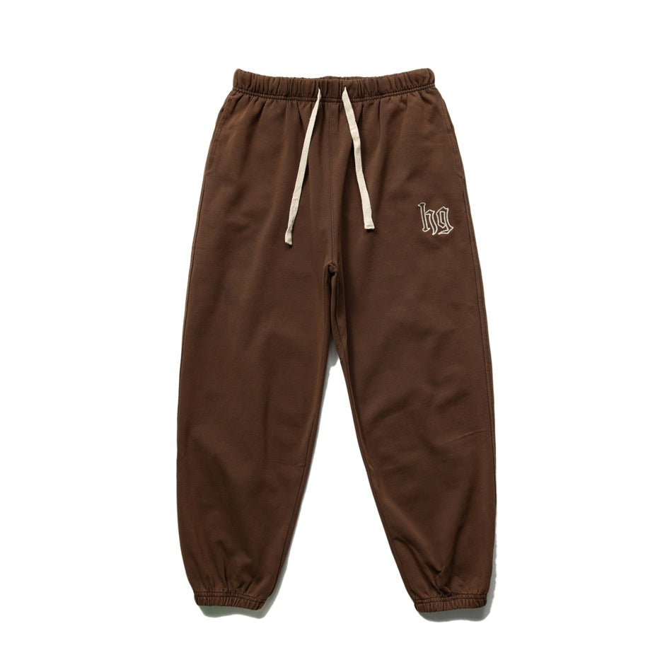 Brown sweatpants flat lay with cream drawstring, elastic cuffs and embroidered hg logo