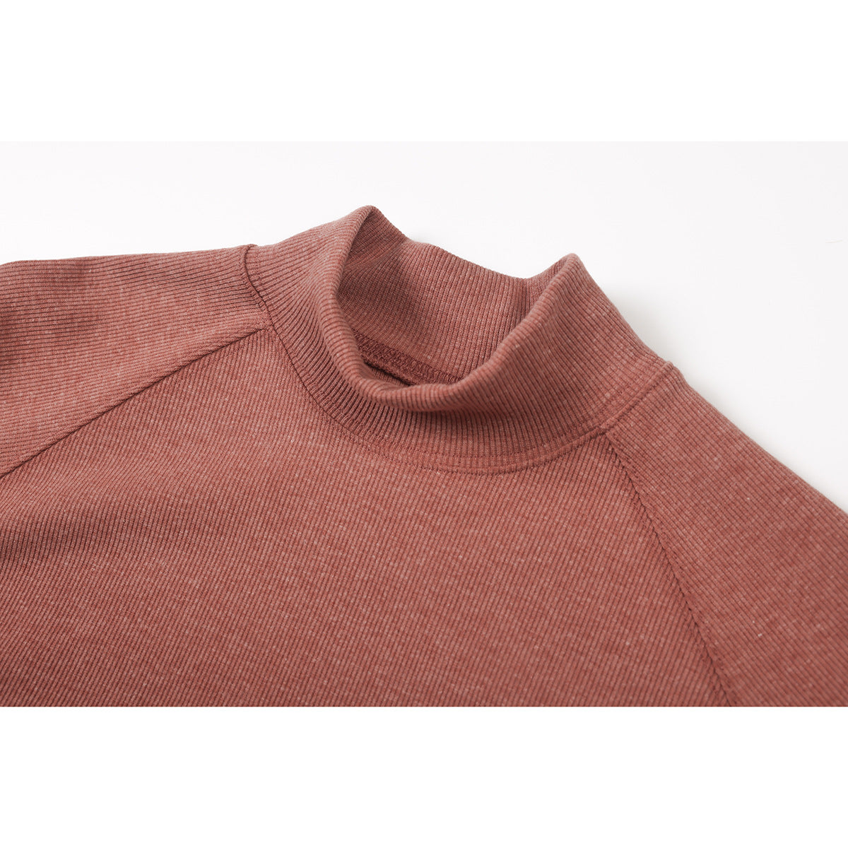 Close-up of a dusty rose ribbed top showing its high collar and raglan shoulder seams.