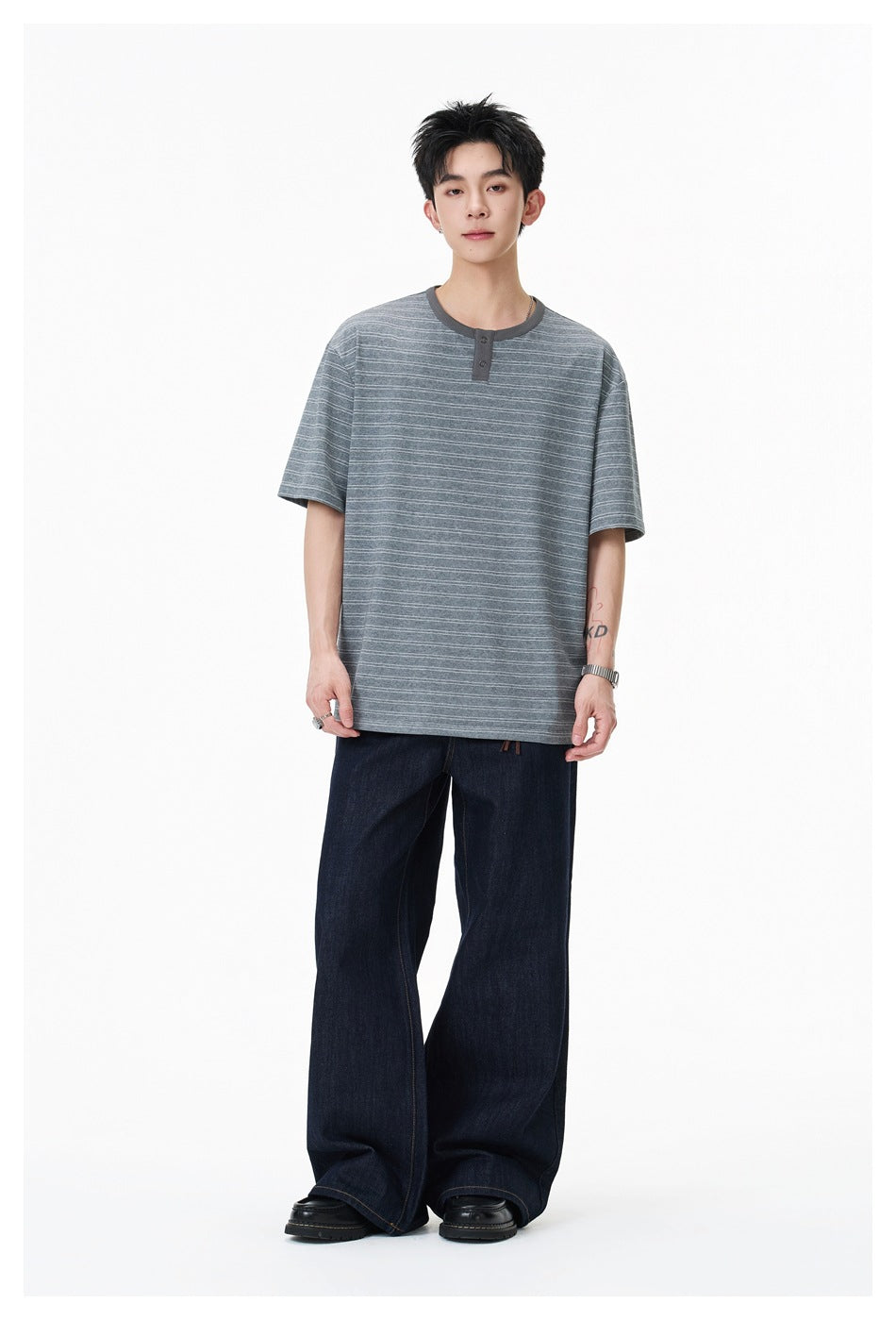 Model wearing gray striped Henley T-shirt with wide-leg dark denim jeans, full-length front view