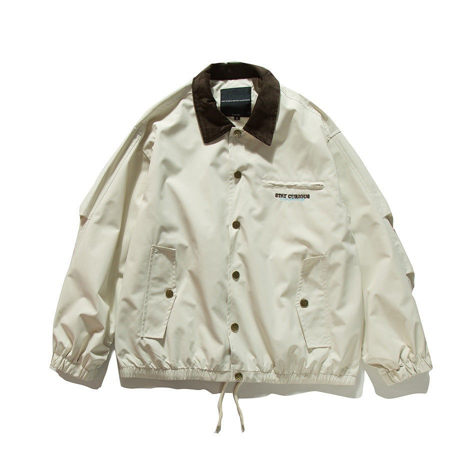 Off-white coach jacket with brown corduroy collar, snap buttons, zip chest pocket and flap pockets, flat lay front view