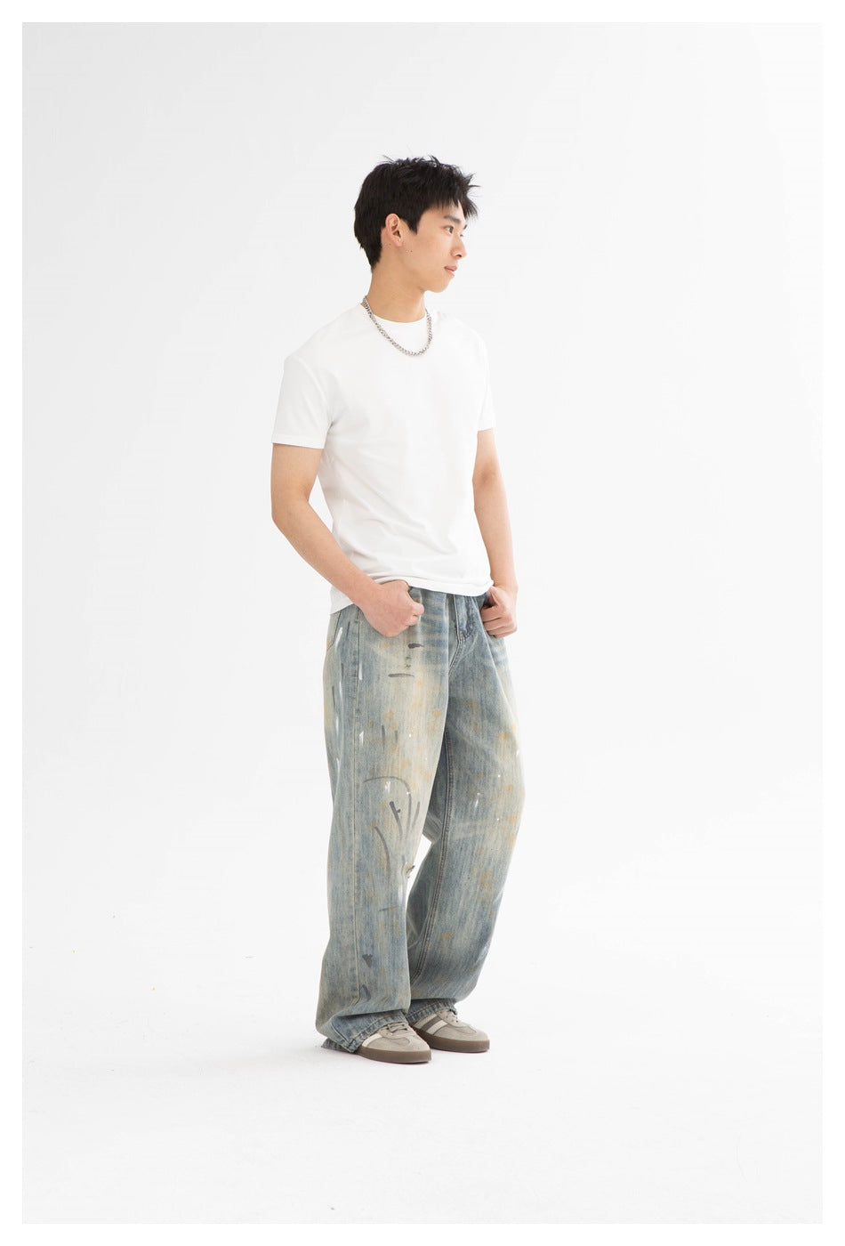 Model in a plain white crew-neck T-shirt and loose, distressed light-wash jeans, shown at an angle.