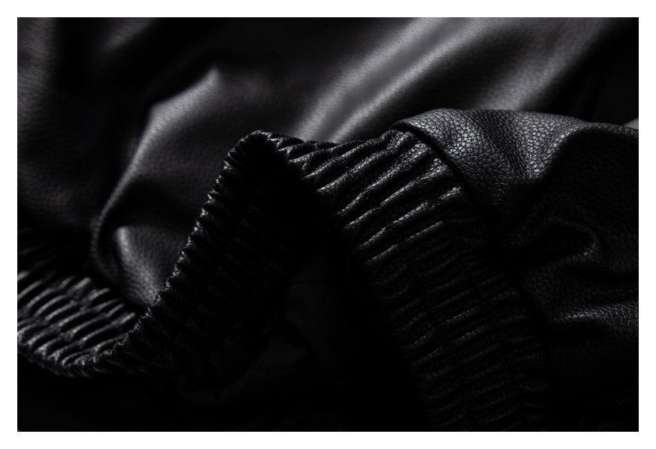 Close-up of black textured garment material with a thick ribbed edge.
