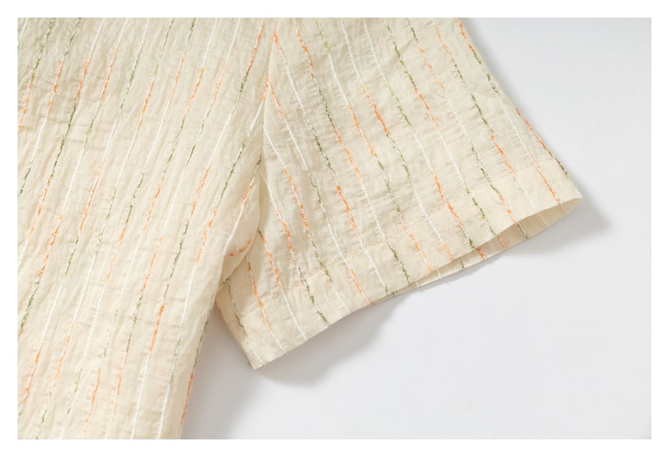 Close-up of a short sleeve on an ivory shirt with textured orange and olive stripes.