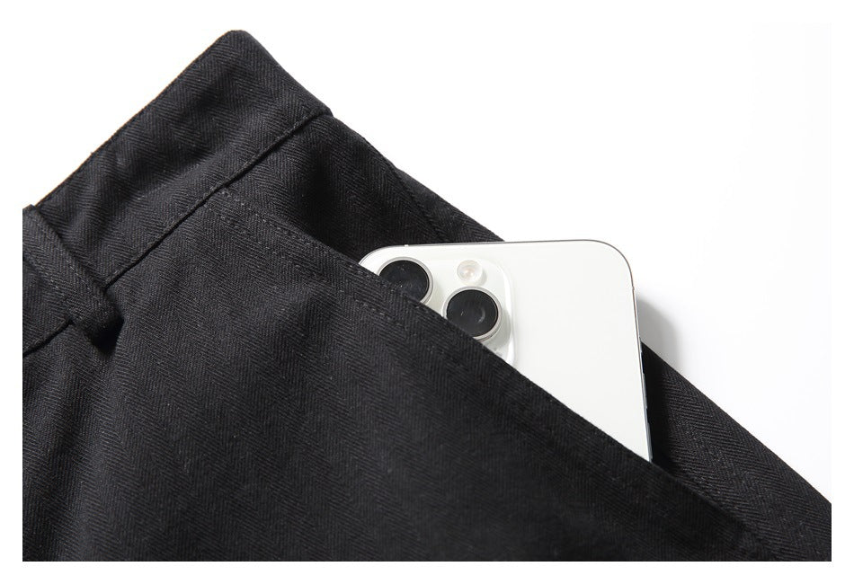 Close-up of a black garment pocket holding a white smartphone.