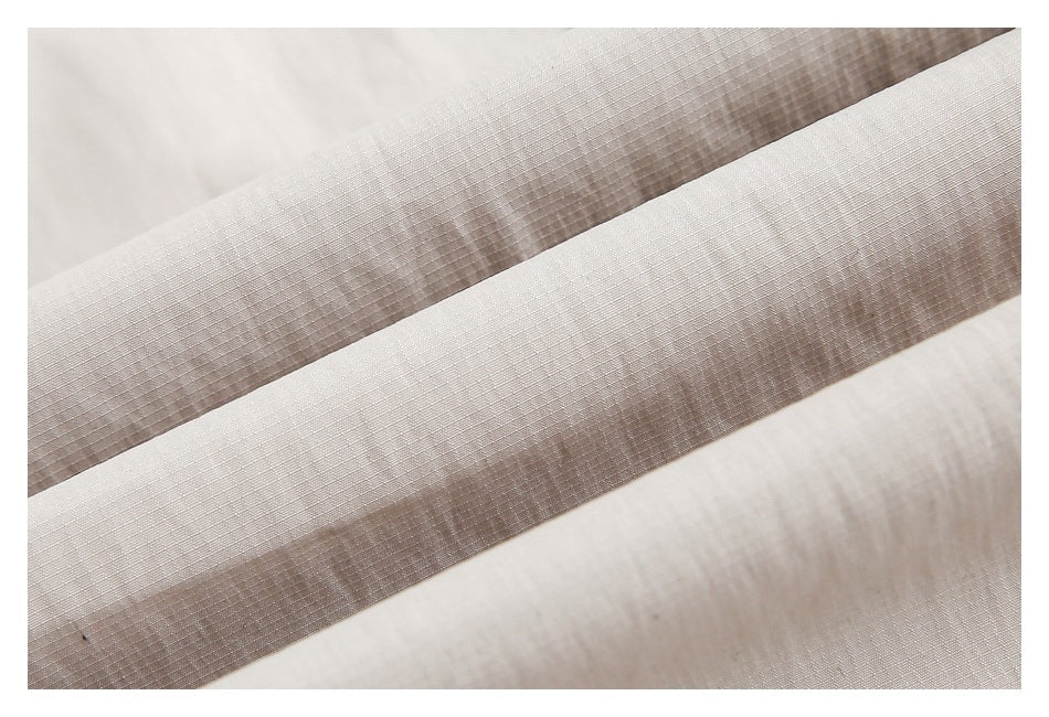 Macro view of the light beige trouser fabric and its fine woven texture.