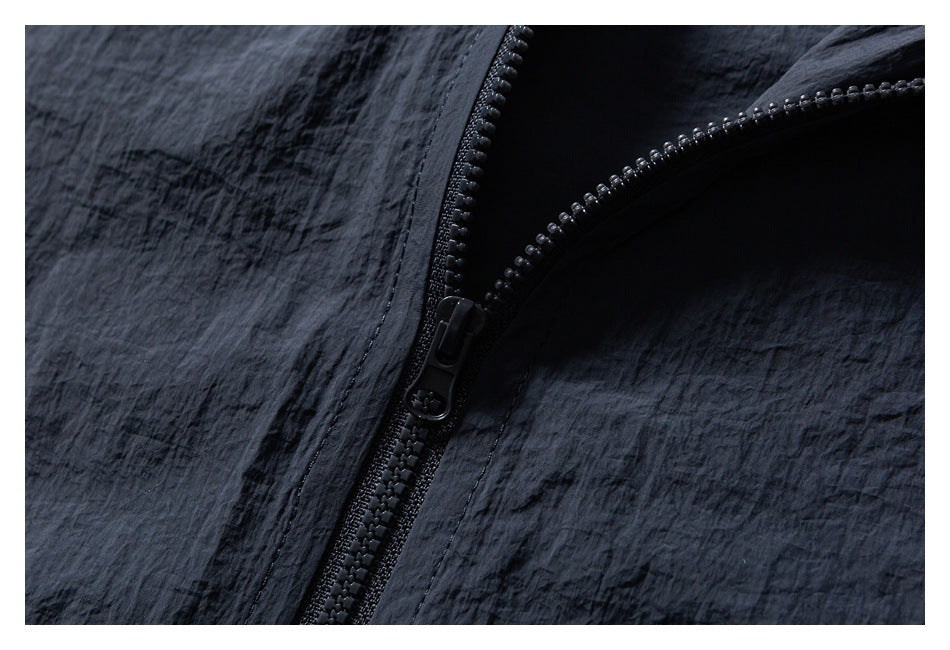 Close-up of a black zipper and textured fabric on a dark garment.