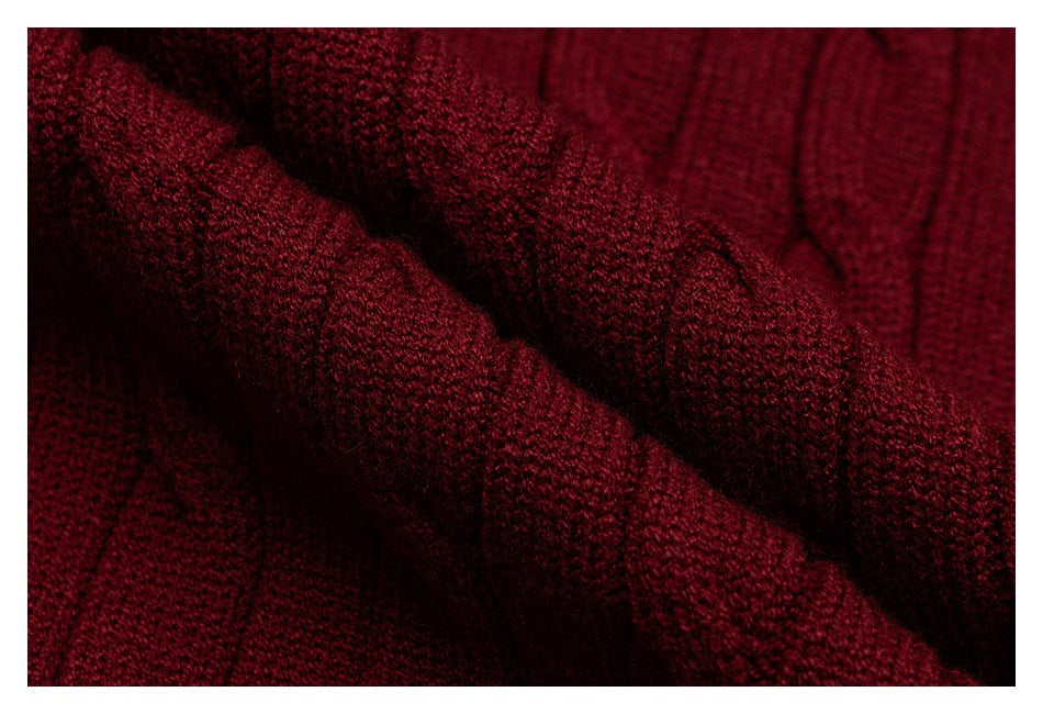Macro view of the burgundy sweater's textured knit stitches and raised cable detail.