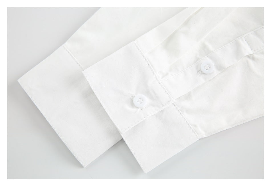 Close-up of a white shirt cuff with two buttons and stitched seams.