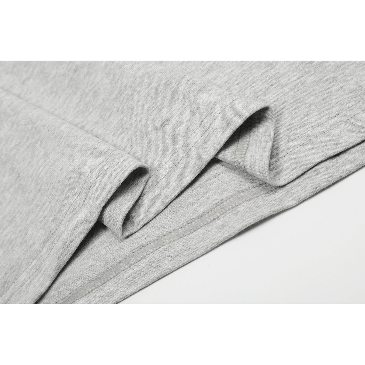 Close-up of the gray T-shirt's folded bottom hem and stitching.