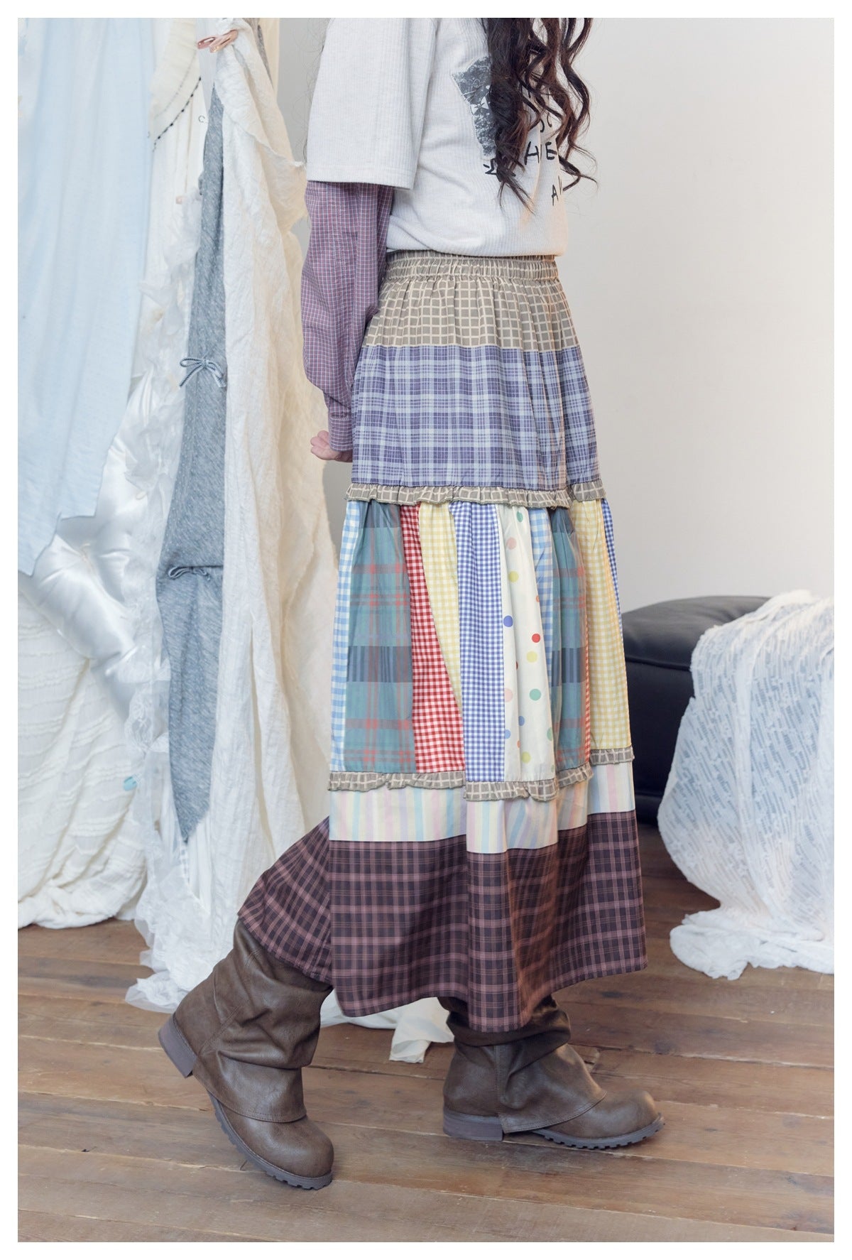 Side view of a model wearing a long tiered patchwork skirt with plaid, checks, dots and pastel stripes.