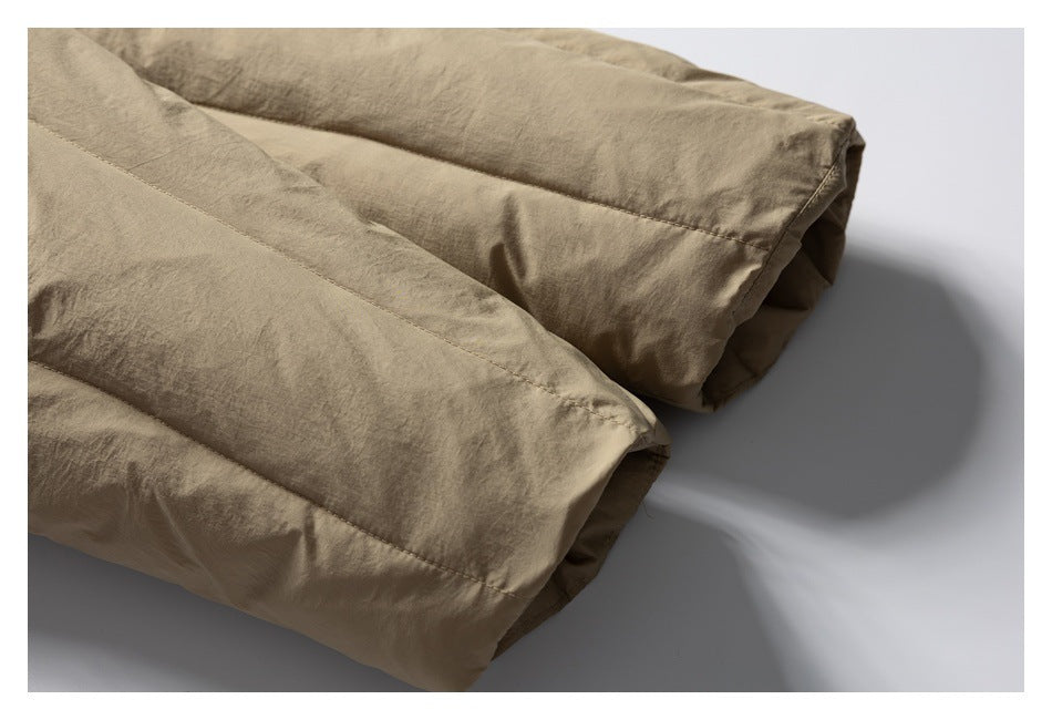 Close-up of two tan padded jacket sleeve ends with stitched seams.