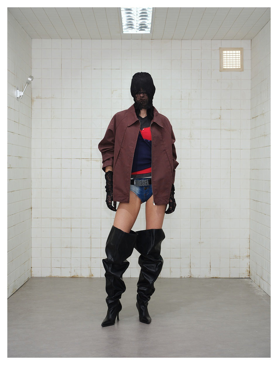 Model wearing a burgundy zip-front jacket with a wide collar, styled with shorts and tall black boots.