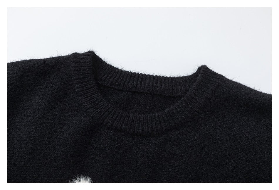 Partial upper-front view of a black sweater showing its ribbed crew neckline.