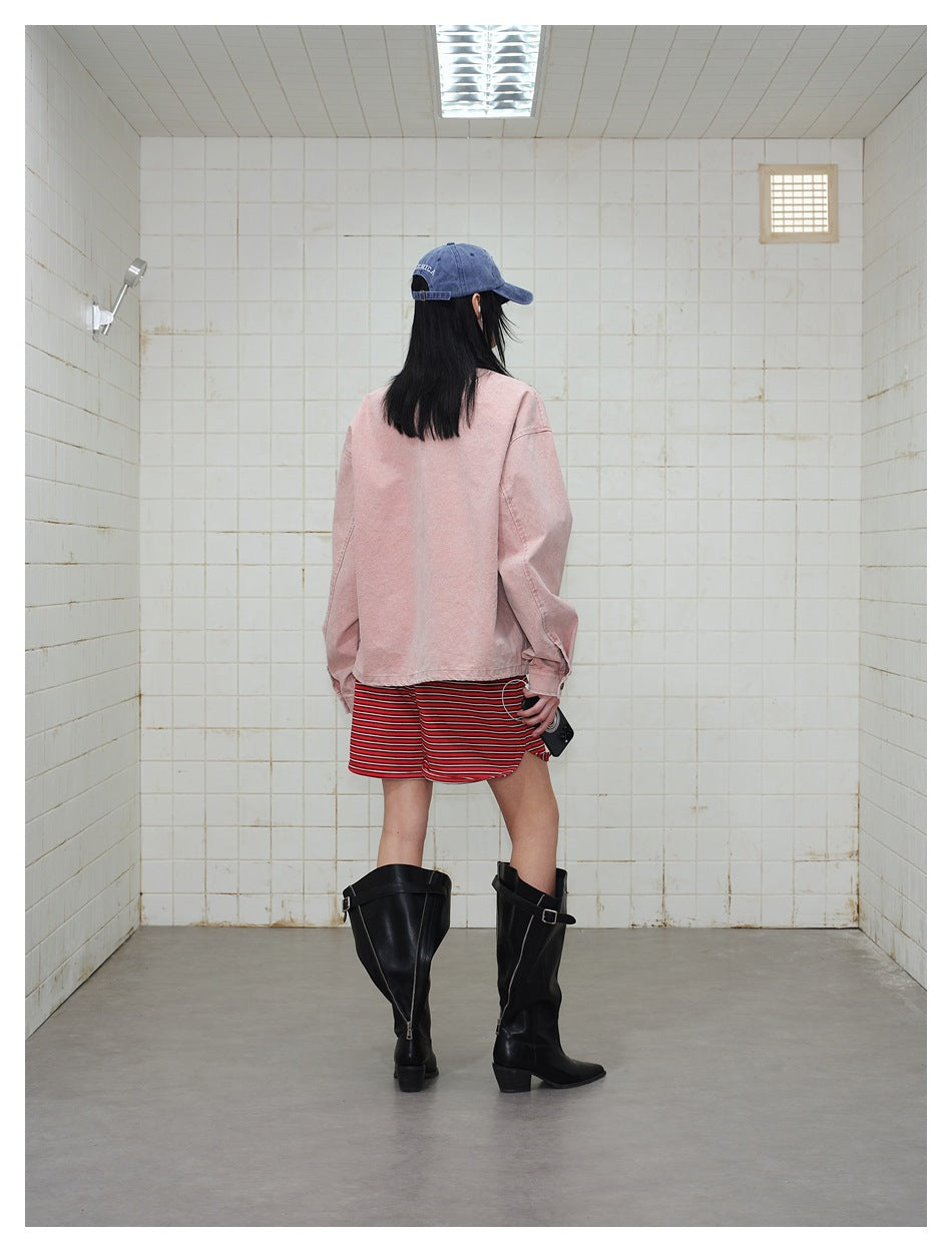 Back view of a model wearing the pink jacket with red striped shorts, blue cap and black knee-high boots