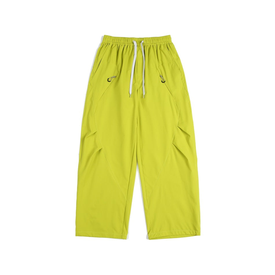 Yellow-green wide-leg drawstring pants with diagonal seams and hip pockets, flat lay front view