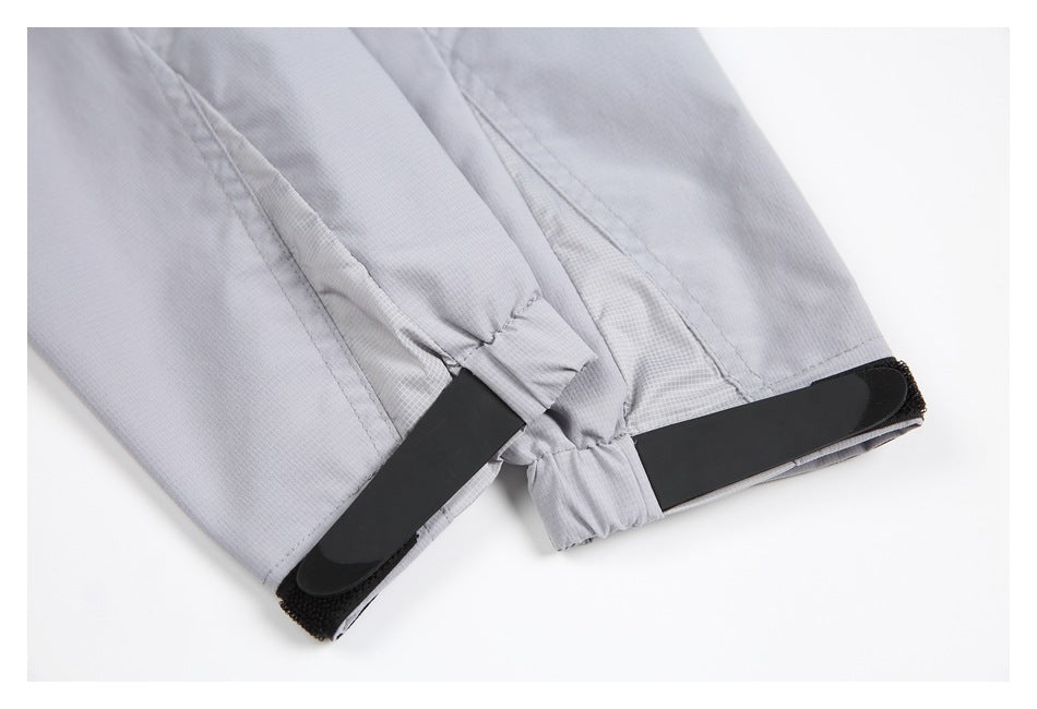 Close-up of a light gray jacket cuff with a black hook-and-loop adjustment tab.