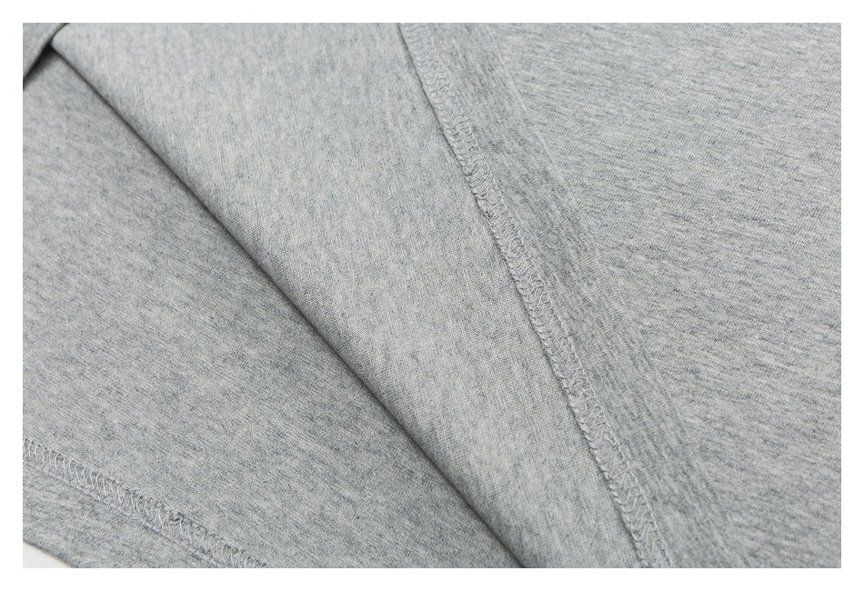 Close-up of a heather-gray T-shirt's interior seams and overlock stitching.