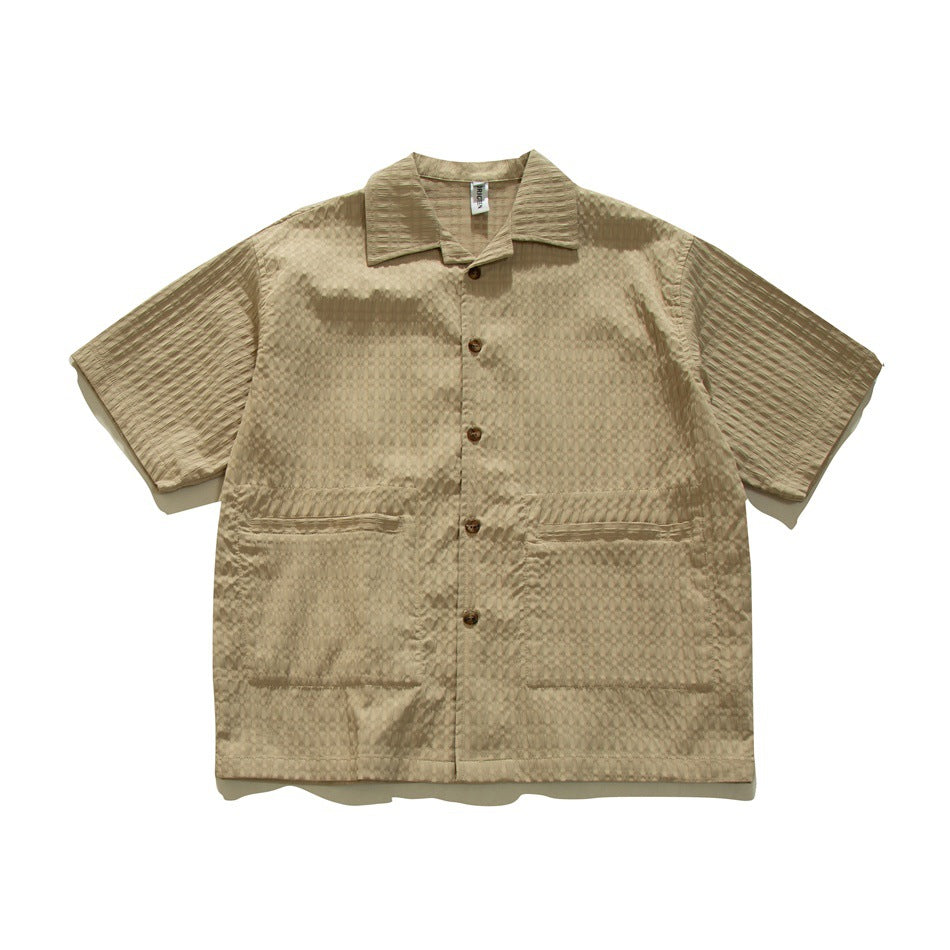 Khaki short-sleeve textured button-up shirt with collar and two large front patch pockets, flat lay