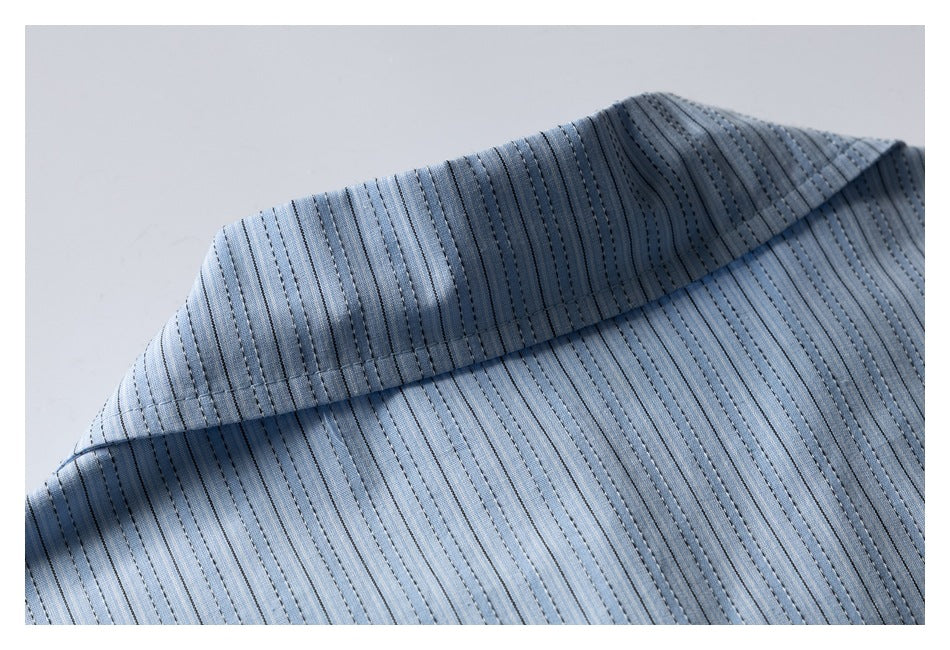 Close-up of a light blue garment collar with narrow dark vertical stripes and parallel stitching.