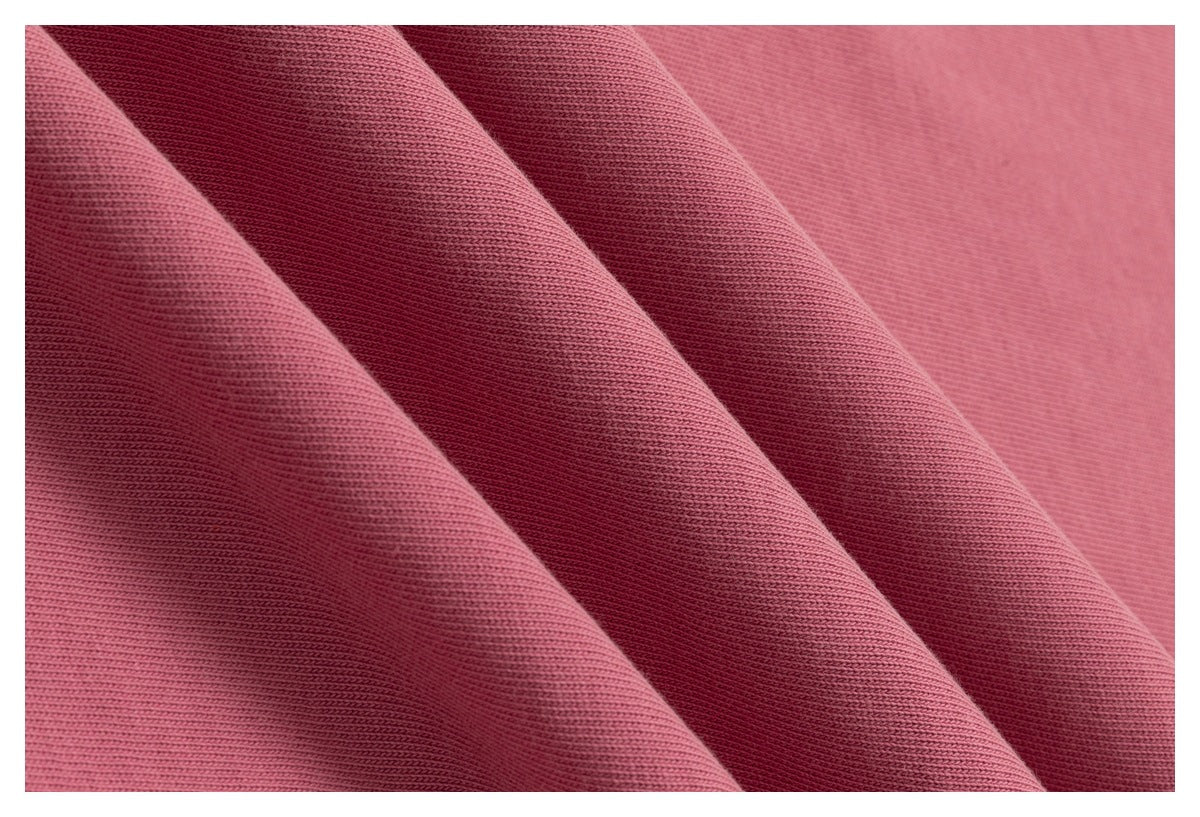 Close-up of dusty pink fabric folds showing its fine knit texture.