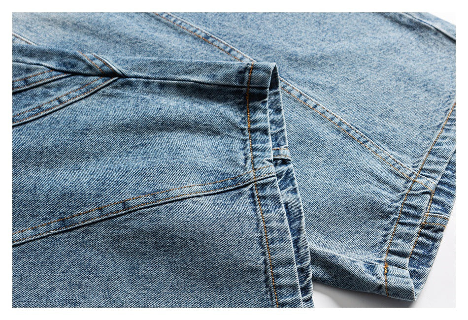 Close-up of light blue jeans showing the stitched hem and overlapping denim panels.