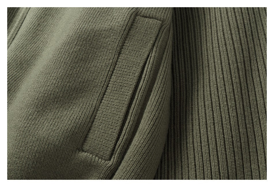 Close-up of a welt pocket on an olive-gray ribbed knit garment.