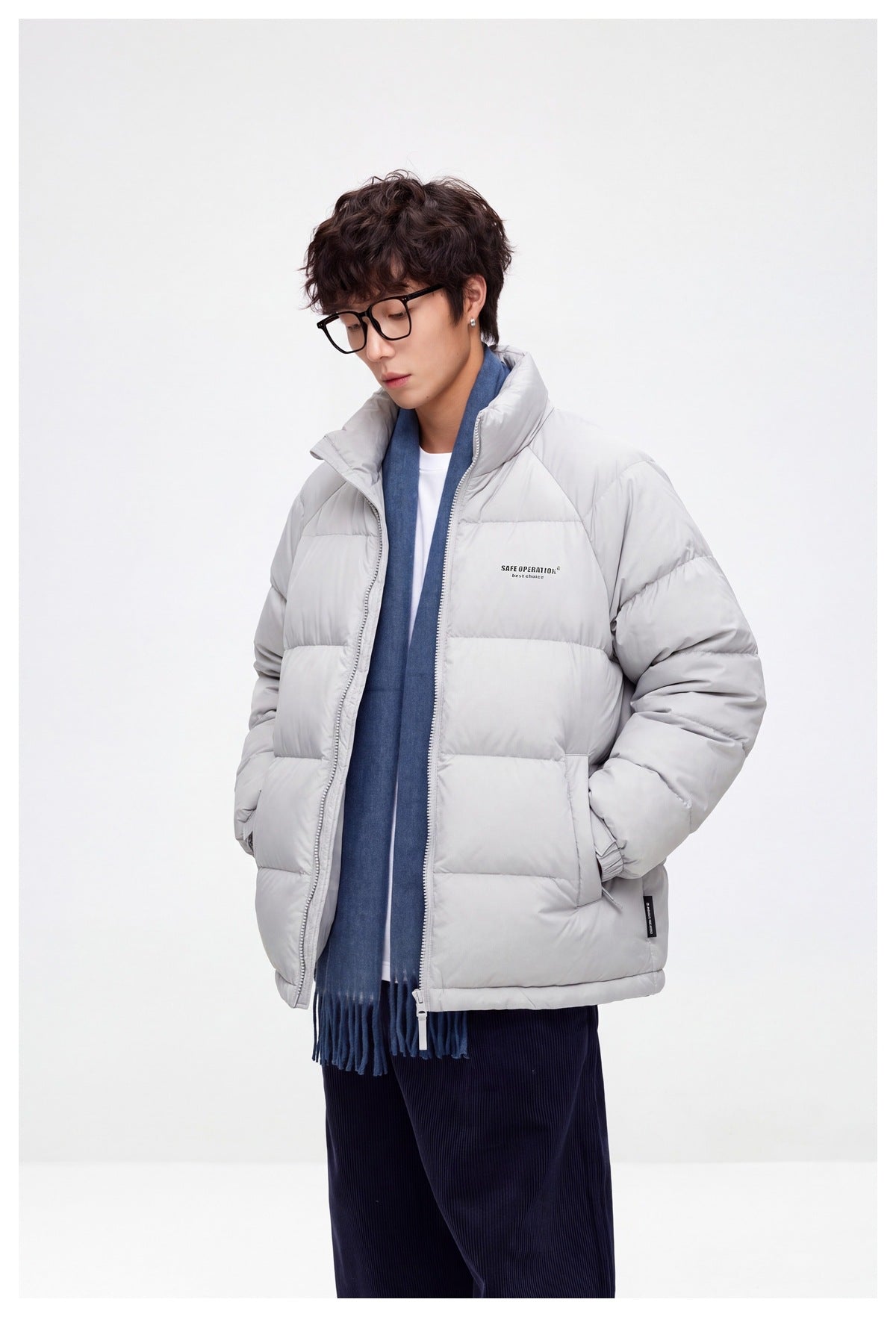 Model in a light gray quilted puffer jacket, shown at an angle with the front zipper and high collar visible.