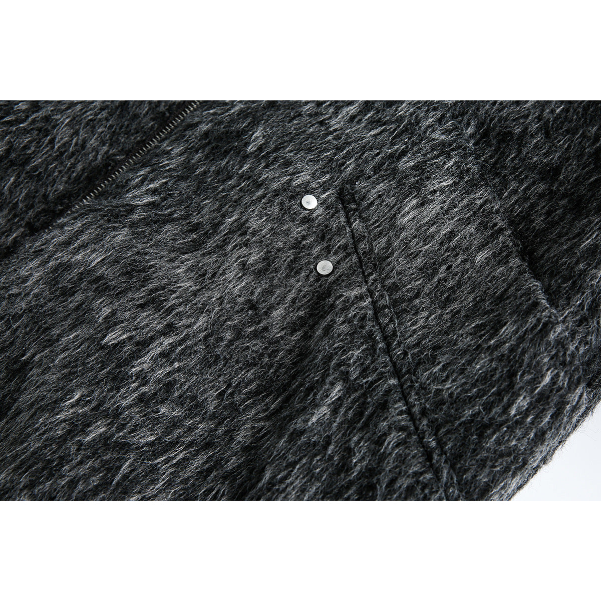 Close-up of two silver snaps and a seam on the charcoal gray fuzzy jacket.