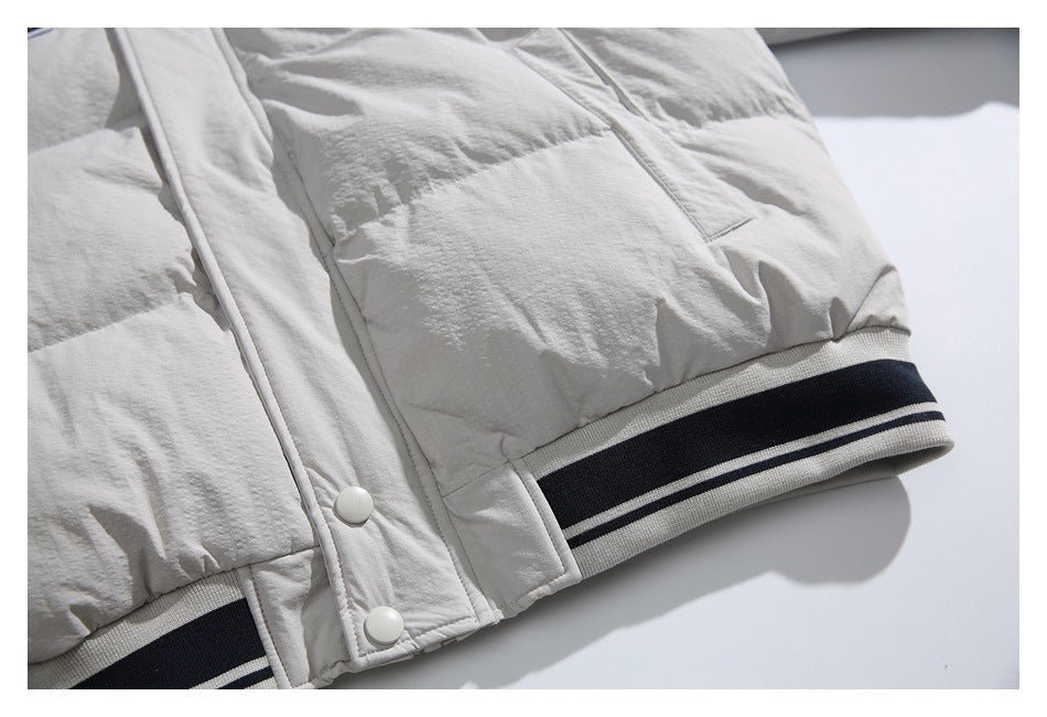 Cropped lower-front view of the light jacket, showing snap fasteners and striped ribbed hem.