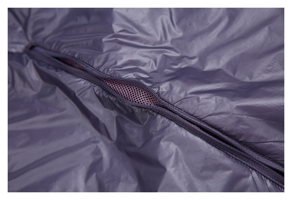 Close-up of a diagonal zipper opening with mesh venting on shiny lavender-gray fabric.