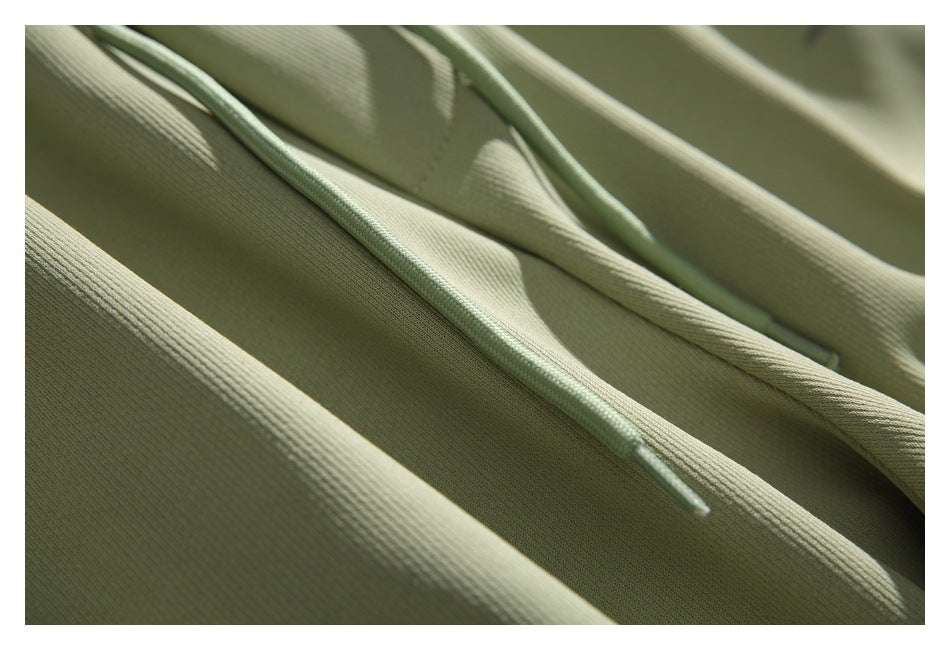 Close-up of pale sage pants showing the drawstring ends and textured fabric.