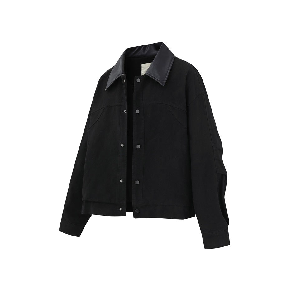 Front view of a black snap-front jacket with a glossy pointed collar, long sleeves, and curved chest seams.